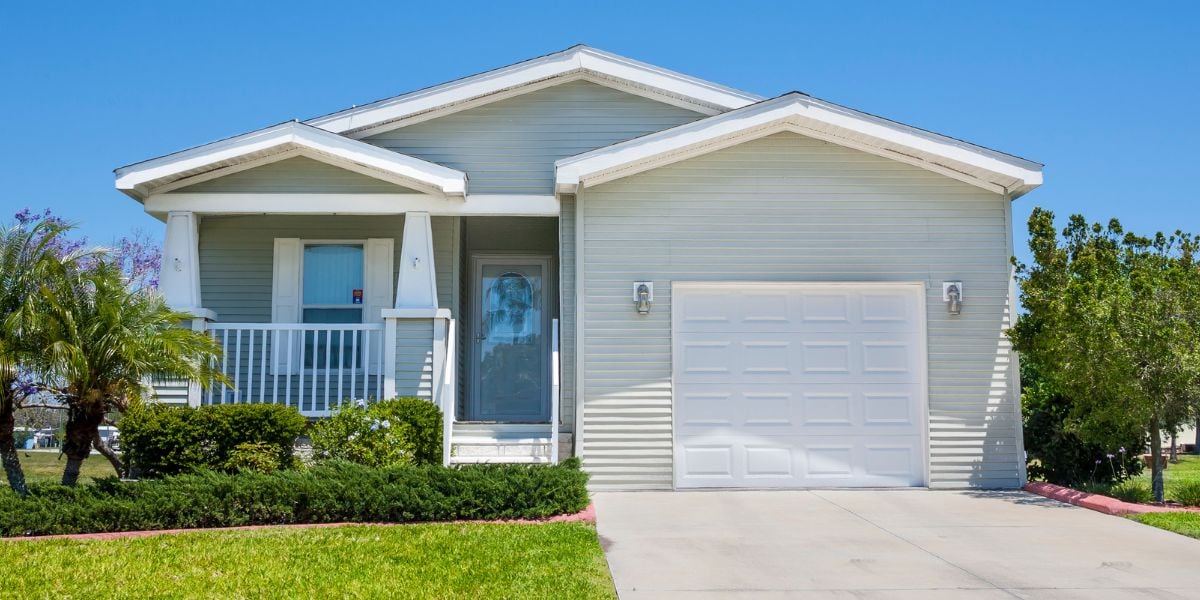 Modern single-story house with a garage and a welcoming front porch, symbolizing the profitable opportunity of cash-flowing rental properties for real estate investors.