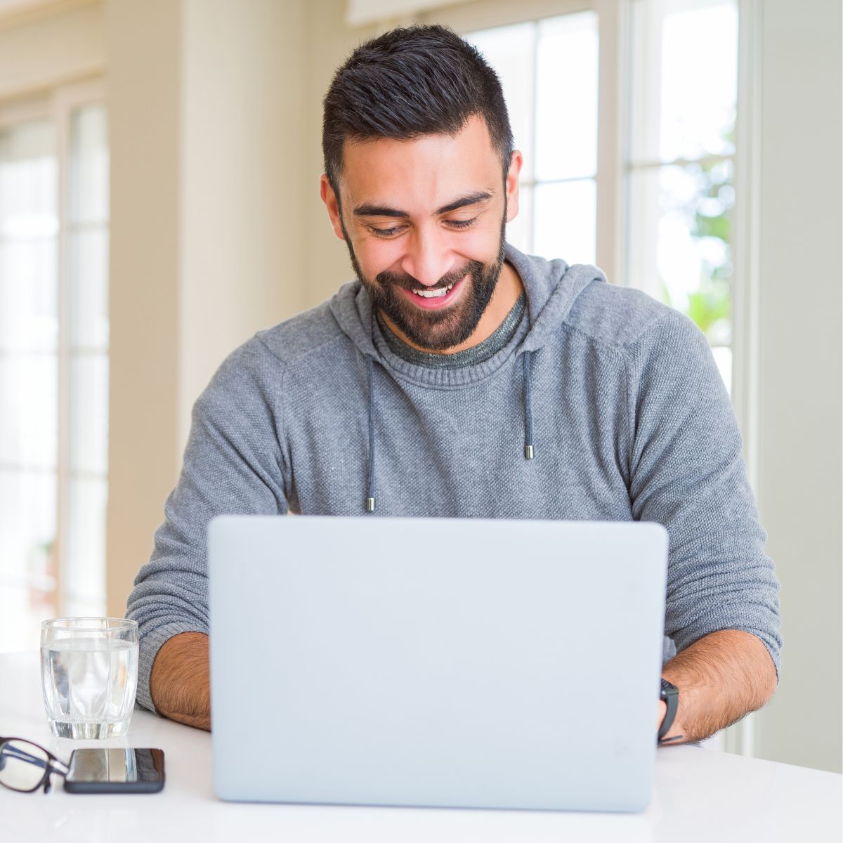 New_Real_Estate_Investor_Smiling_at_Laptop